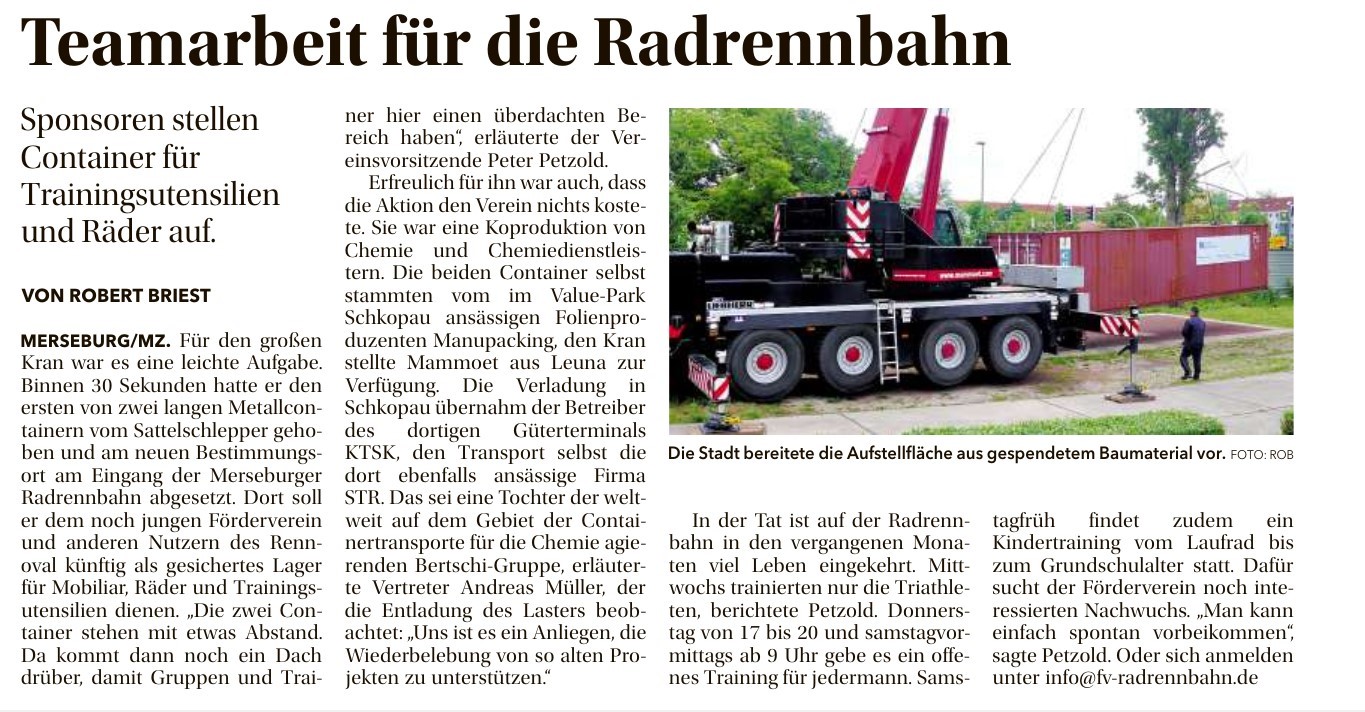 Ein Kran stellt einen Container auf der Radrennbahn in Merseburg.