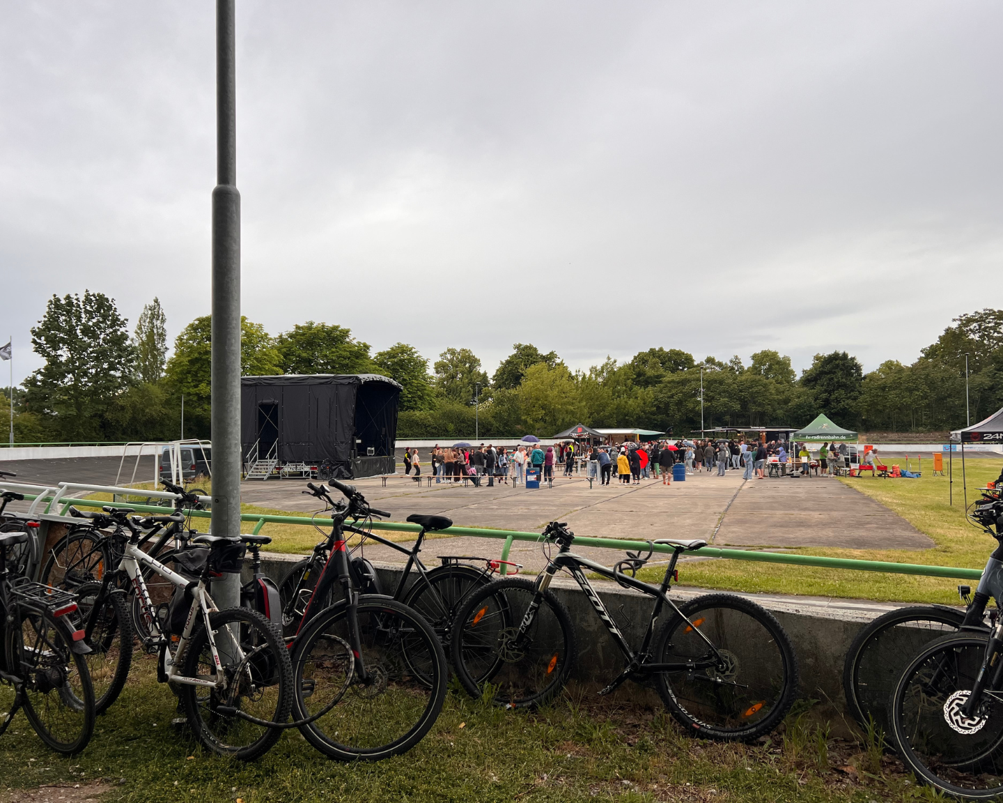 Fahrräder am Rand der Radrennbahn, während im Hintergrund gefeiert wird